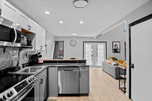 a kitchen with stainless steel appliances granite countertop a stove and cabinets
