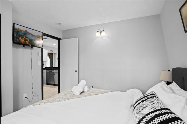 a bedroom with a bed and a painting on the wall