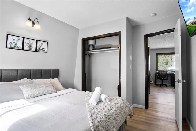 a bedroom with a bed and a painting on the wall