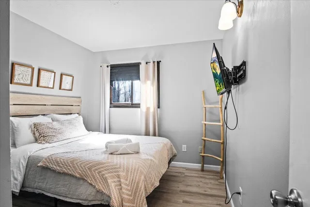 a bedroom with a bed and wooden floor