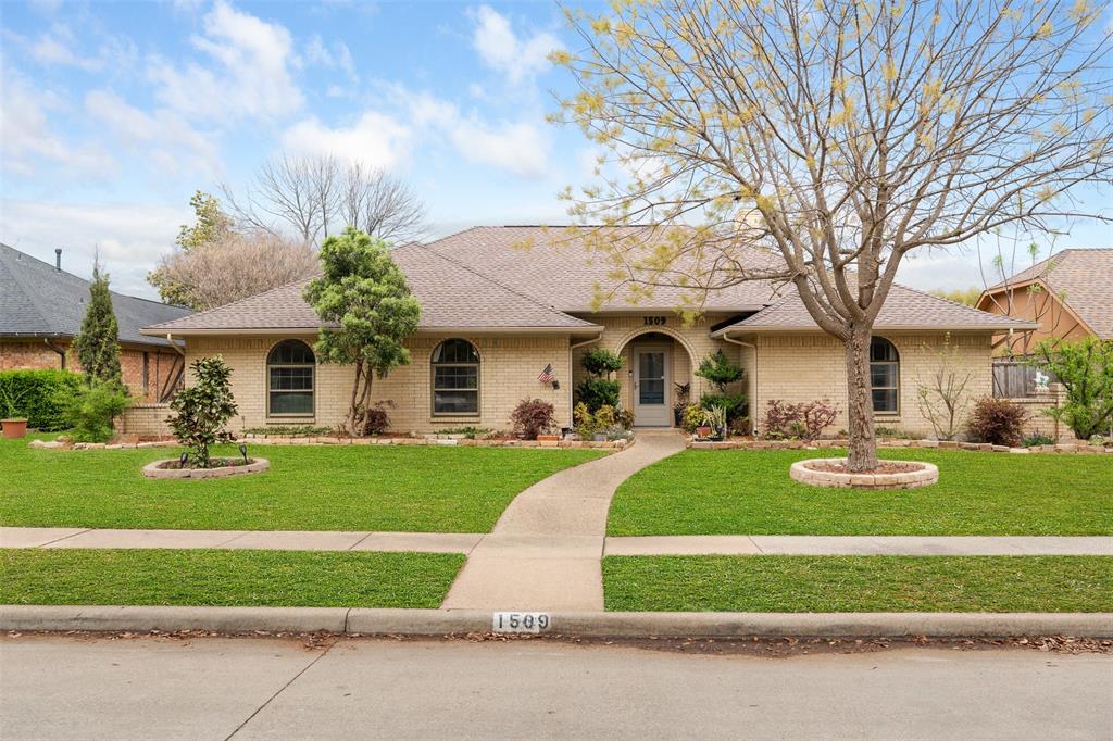Ranch-style house with brick siding, a front yard, and a shingled roof