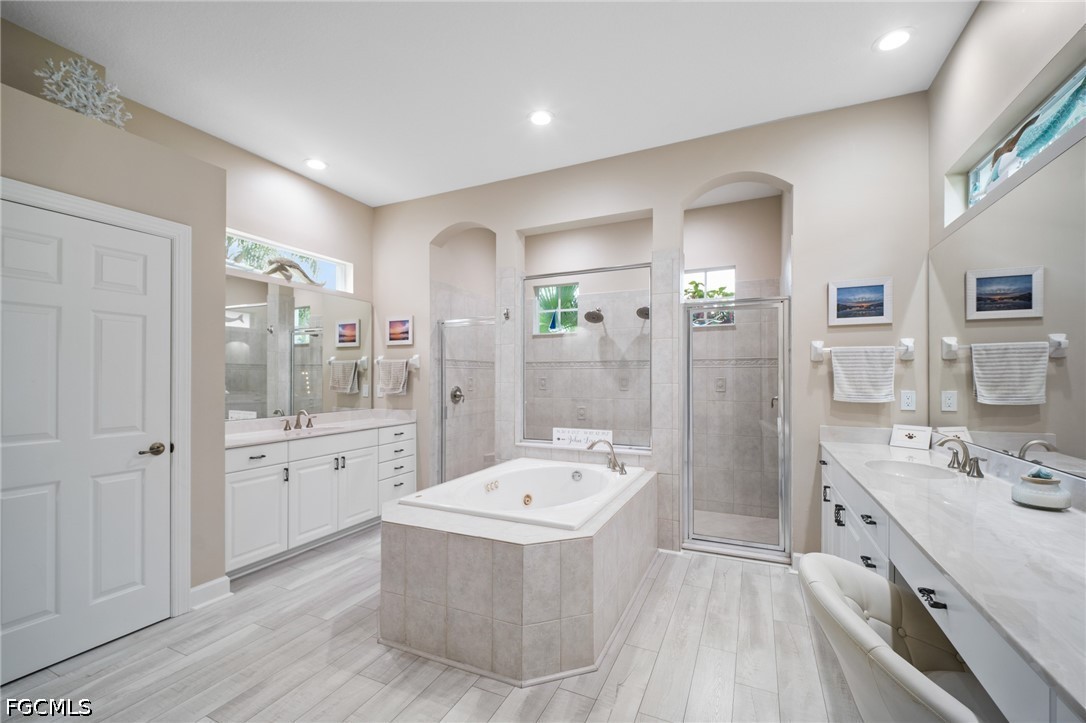 9042 Bronco Court Naples, FL 34113 - Photo 18 of 50 a bathroom with a tub sink double vanity and shower