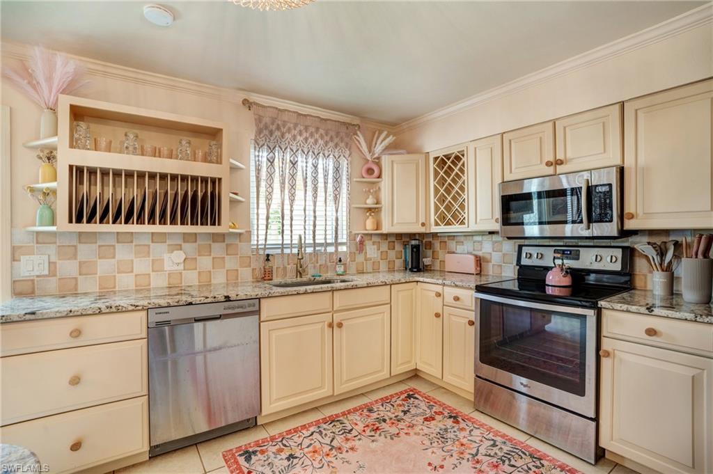 7146 Congdon Road Fort Myers, FL 33908 - Photo 18 of 50 a kitchen with stainless steel appliances granite countertop a stove a sink and a microwave
