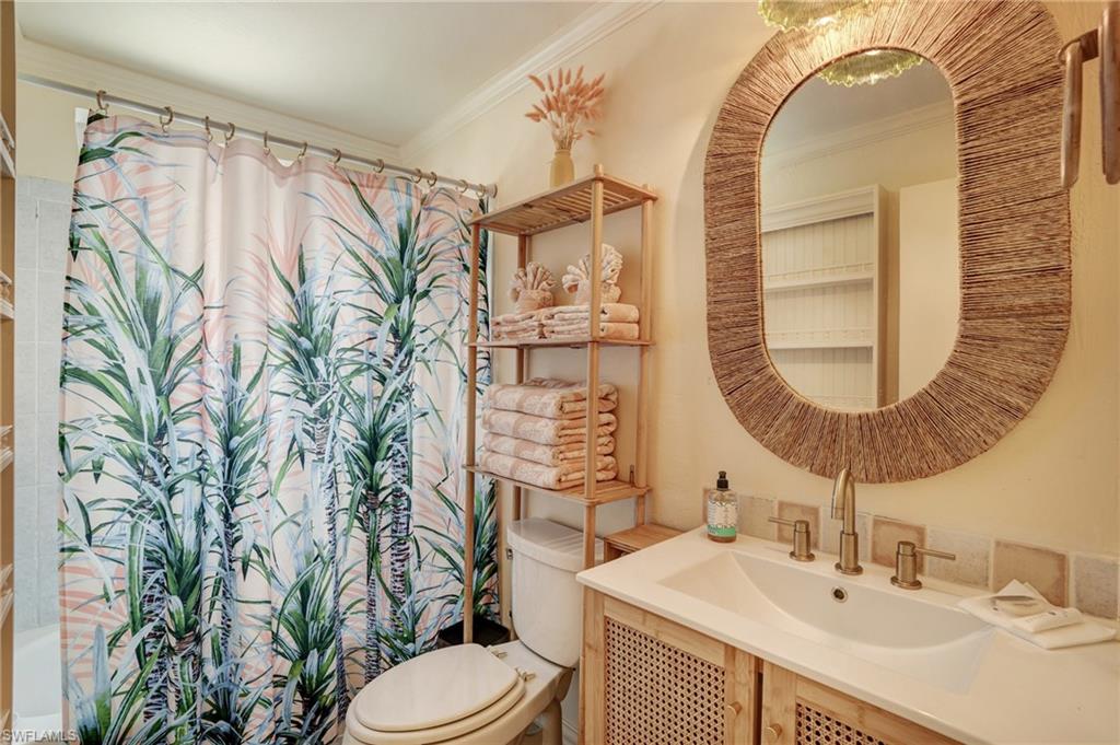 7146 Congdon Road Fort Myers, FL 33908 - Photo 21 of 50 a bathroom with a sink a mirror a toilet and a window
