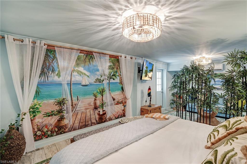 7146 Congdon Road Fort Myers, FL 33908 - Photo 31 of 50 a bedroom with a bed and a chandelier