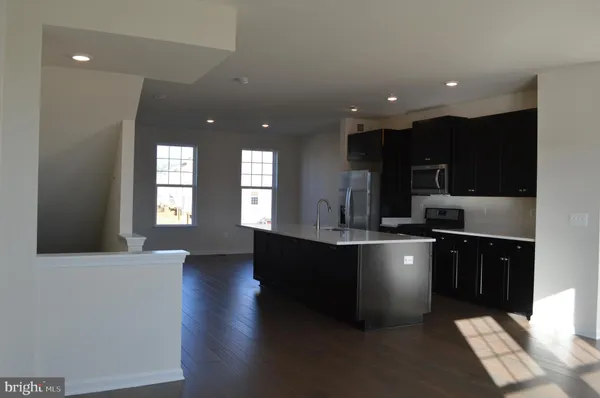 a large kitchen with stainless steel appliances a large counter top