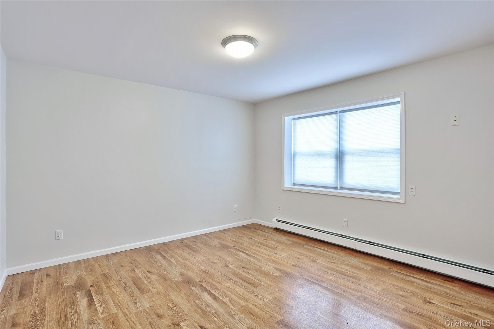 160 Saddle River Road, Unit B Airmont, NY 10952 - Photo 9 of 14 an empty room with wooden floor and windows