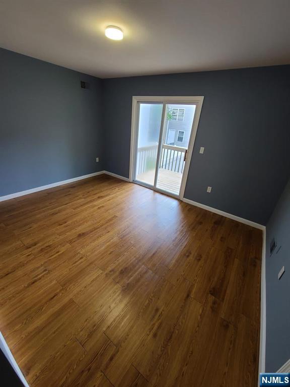 51 Godwin Avenue Paterson, NJ 07501 - Photo 2 of 14 an empty room with wooden floor and windows