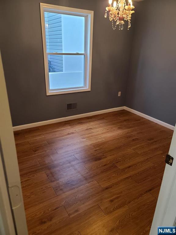 51 Godwin Avenue Paterson, NJ 07501 - Photo 5 of 14 an empty room with wooden floor and windows