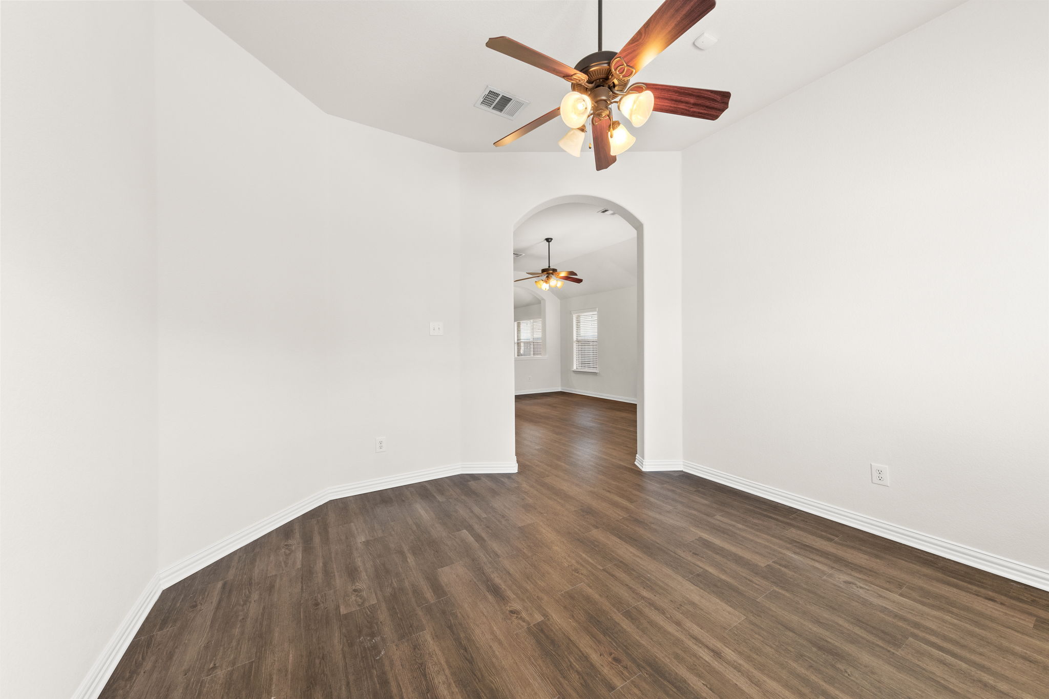 411 Tascate Street Georgetown, TX 78628 - Photo 39 of 41 Rich wood flooring extends through this room, with a subtle archway leading to another area of the house.