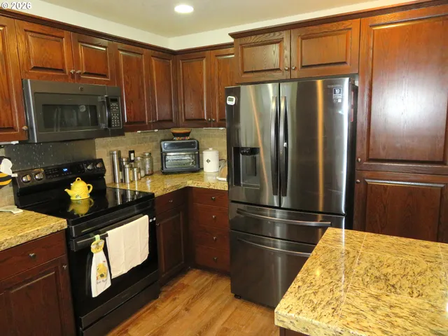 a kitchen with stainless steel appliances granite countertop a refrigerator and a stove top oven