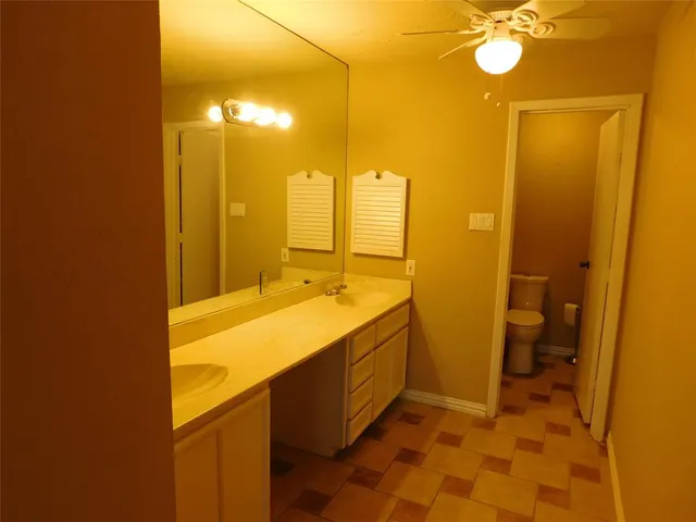 a bathroom with a sink mirror vanity and toilet