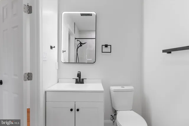 a bathroom with a toilet sink and mirror