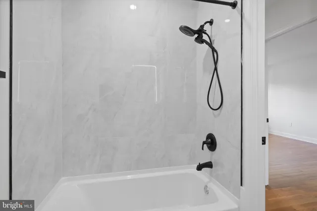 a bathroom with a bath tub with a shower