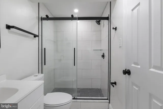 a bathroom with a shower a toilet and a sink
