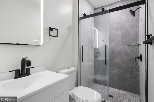 a bathroom with a sink a toilet and shower