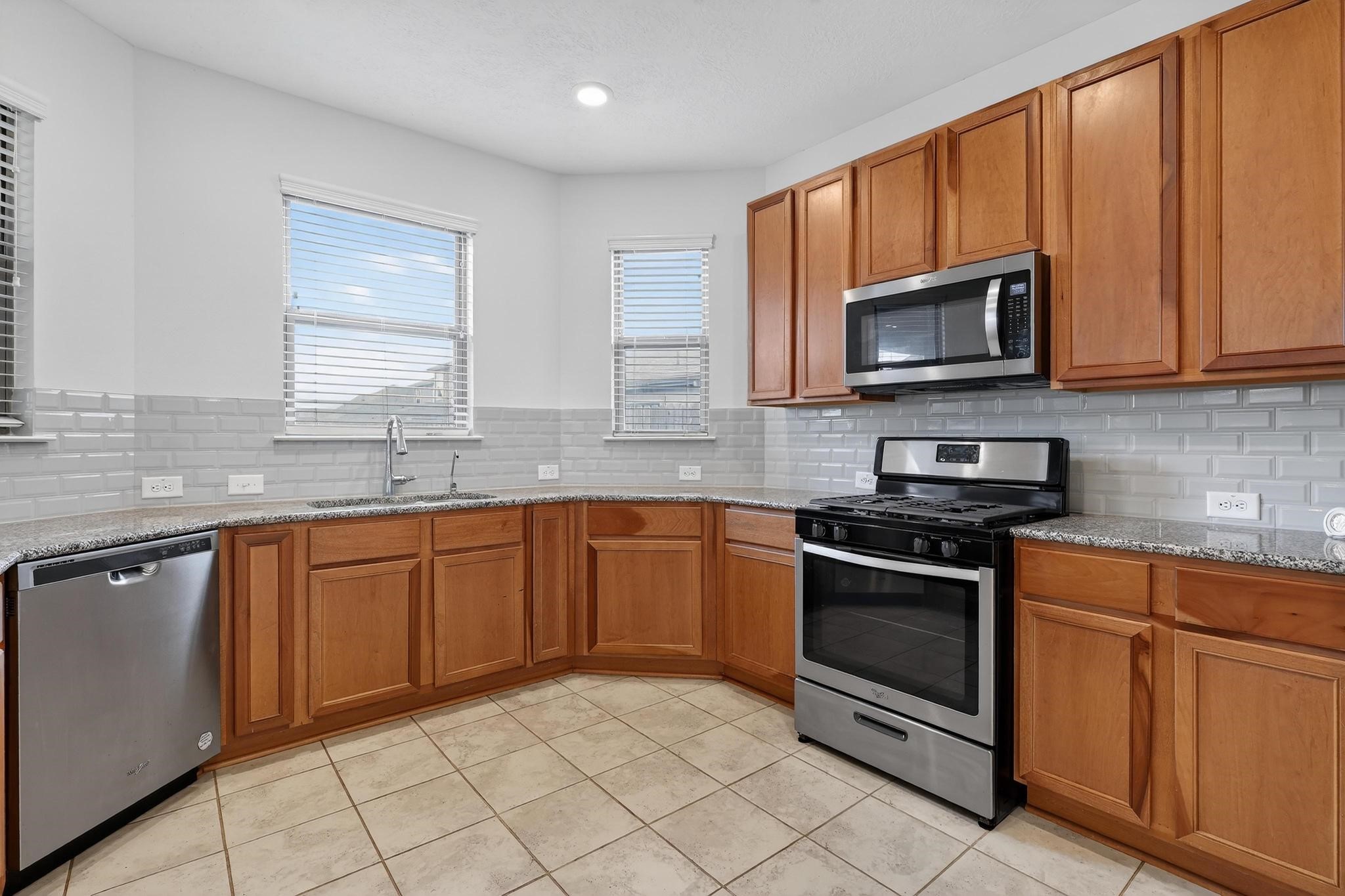 3322 Nila Creek Dr Spring Spring, TX 77373 - Photo 8 of 36 Well-designed kitchen layout offering ample storage, generous counter space, and natural light from multiple windows.