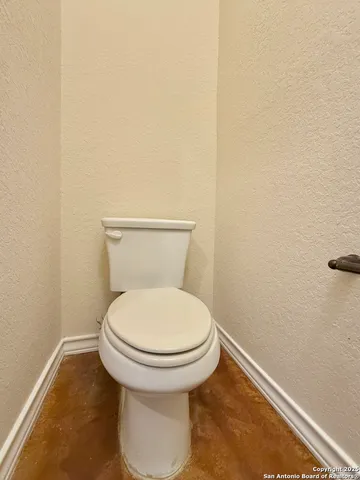 a white toilet sitting next to a white wall