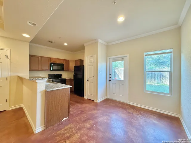 a view of kitchen with stainless steel appliances kitchen island wooden cabinets and window