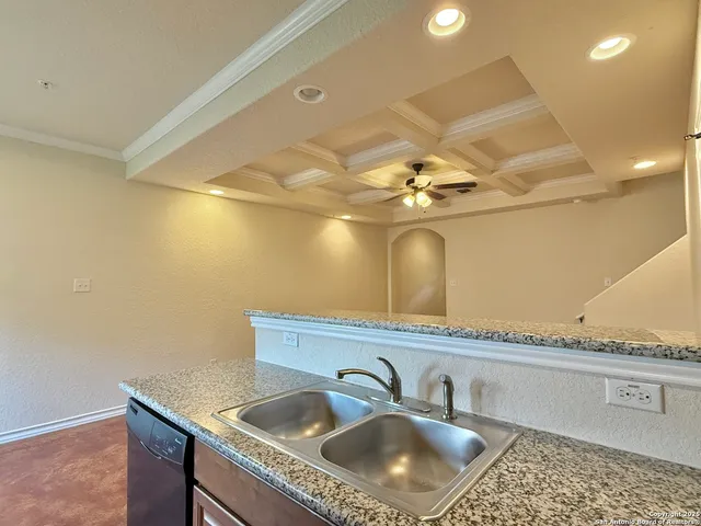 a kitchen with a sink a counter space and a chandelier