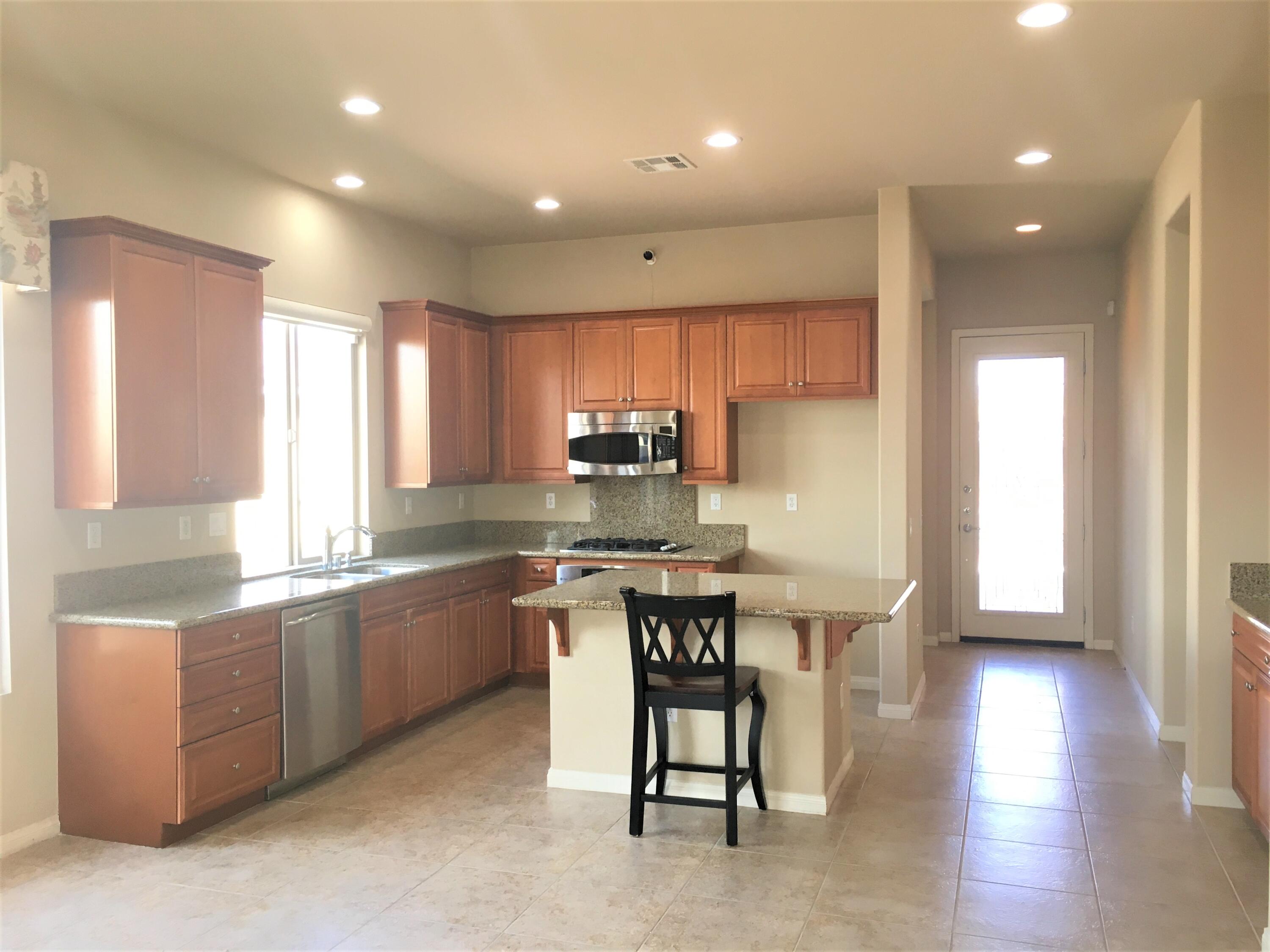 39929 Corte De Moda Indio, CA 92203 - Photo 10 of 46 a kitchen with kitchen island granite countertop a sink and white cabinets