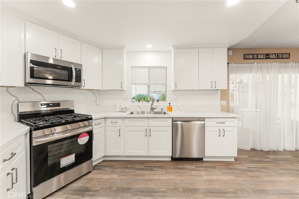 35218 Fir Avenue, Unit 183 Yucaipa, CA 92399 - Photo 11 of 35 a kitchen with stainless steel appliances a stove a sink and a microwave