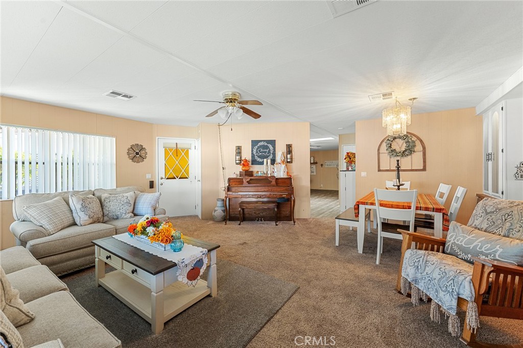 35218 Fir Avenue, Unit 183 Yucaipa, CA 92399 - Photo 6 of 35 a living room with furniture a chandelier and a window