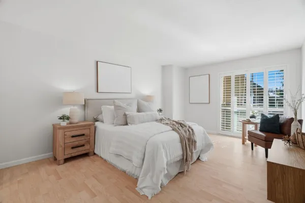a bedroom with a bed and large windows