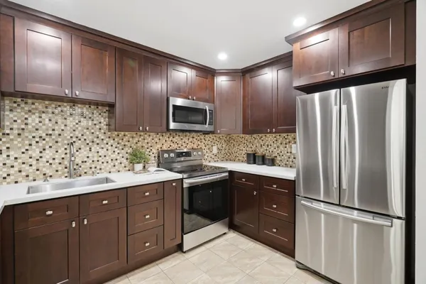 a kitchen with stainless steel appliances granite countertop a refrigerator and a sink