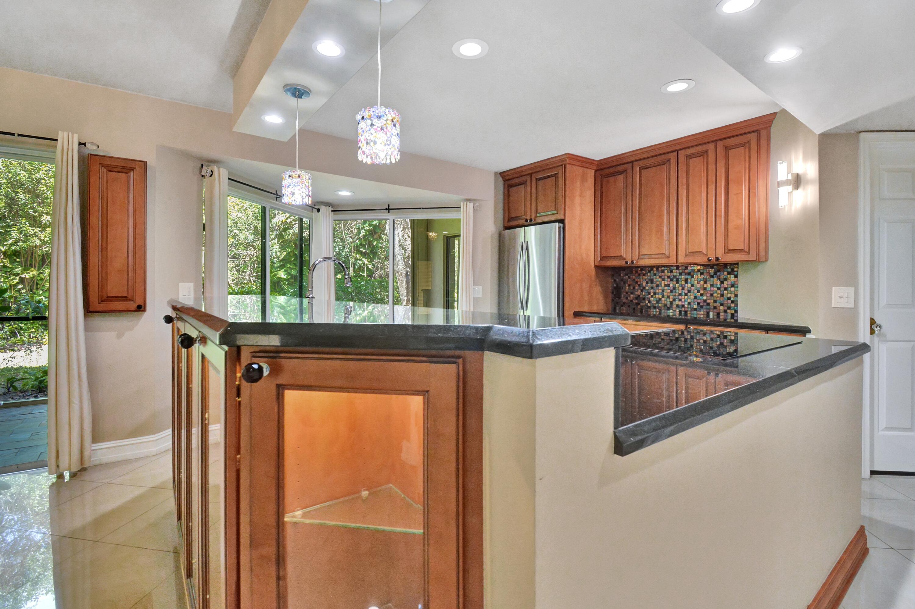 5590 Coach House Circle, Unit A Boca Raton, FL 33486 - Photo 12 of 33 a kitchen with stainless steel appliances granite countertop a stove a sink and a refrigerator