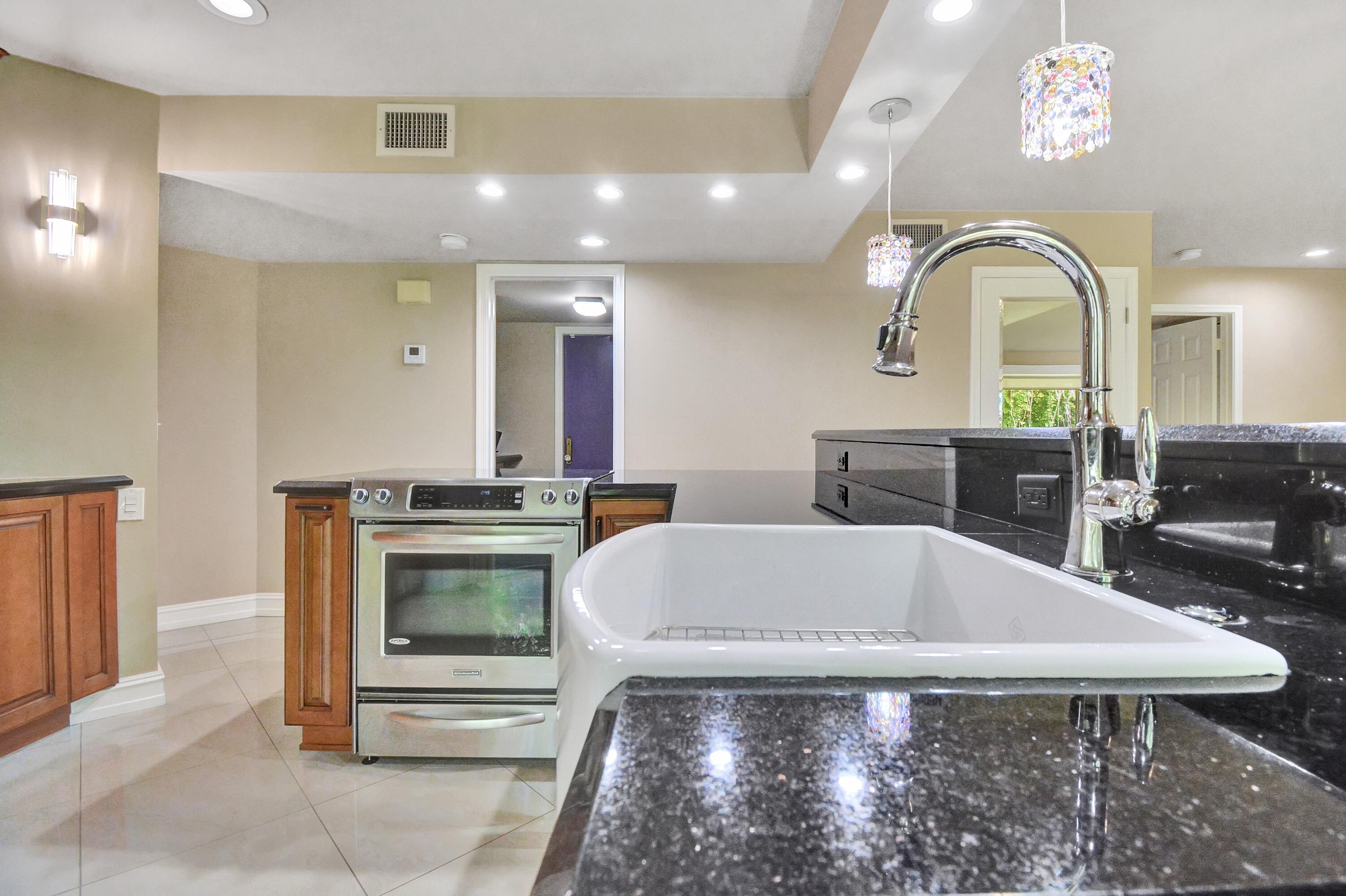 5590 Coach House Circle, Unit A Boca Raton, FL 33486 - Photo 13 of 33 a view of a kitchen with a table and chairs