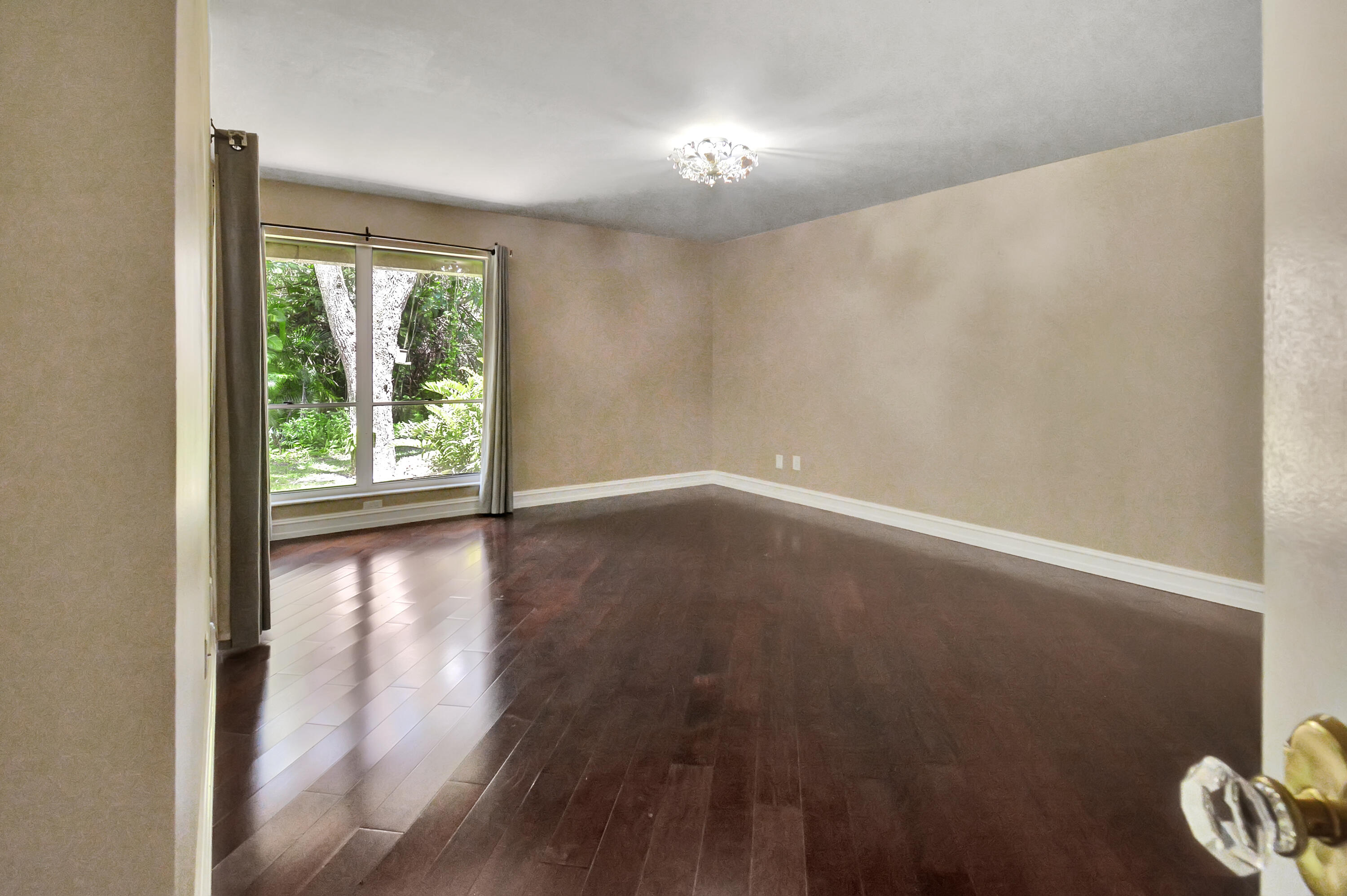 5590 Coach House Circle, Unit A Boca Raton, FL 33486 - Photo 16 of 33 an empty room with wooden floor and windows