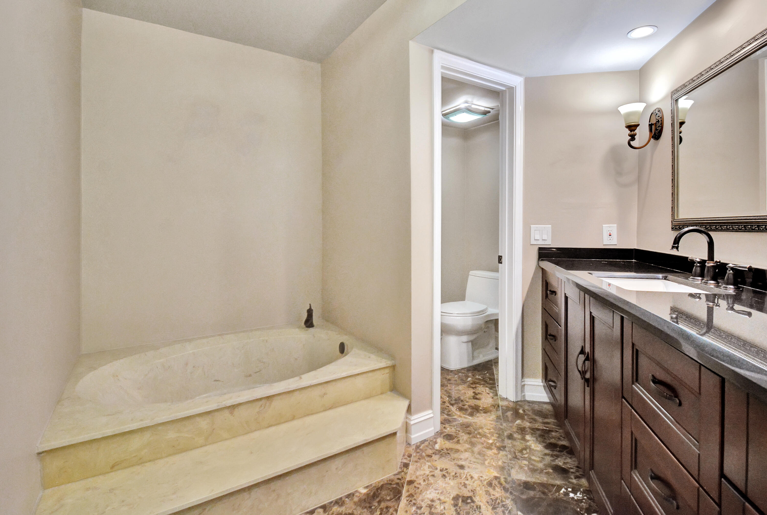 5590 Coach House Circle, Unit A Boca Raton, FL 33486 - Photo 18 of 33 a spacious bathroom with a tub sink and toilet