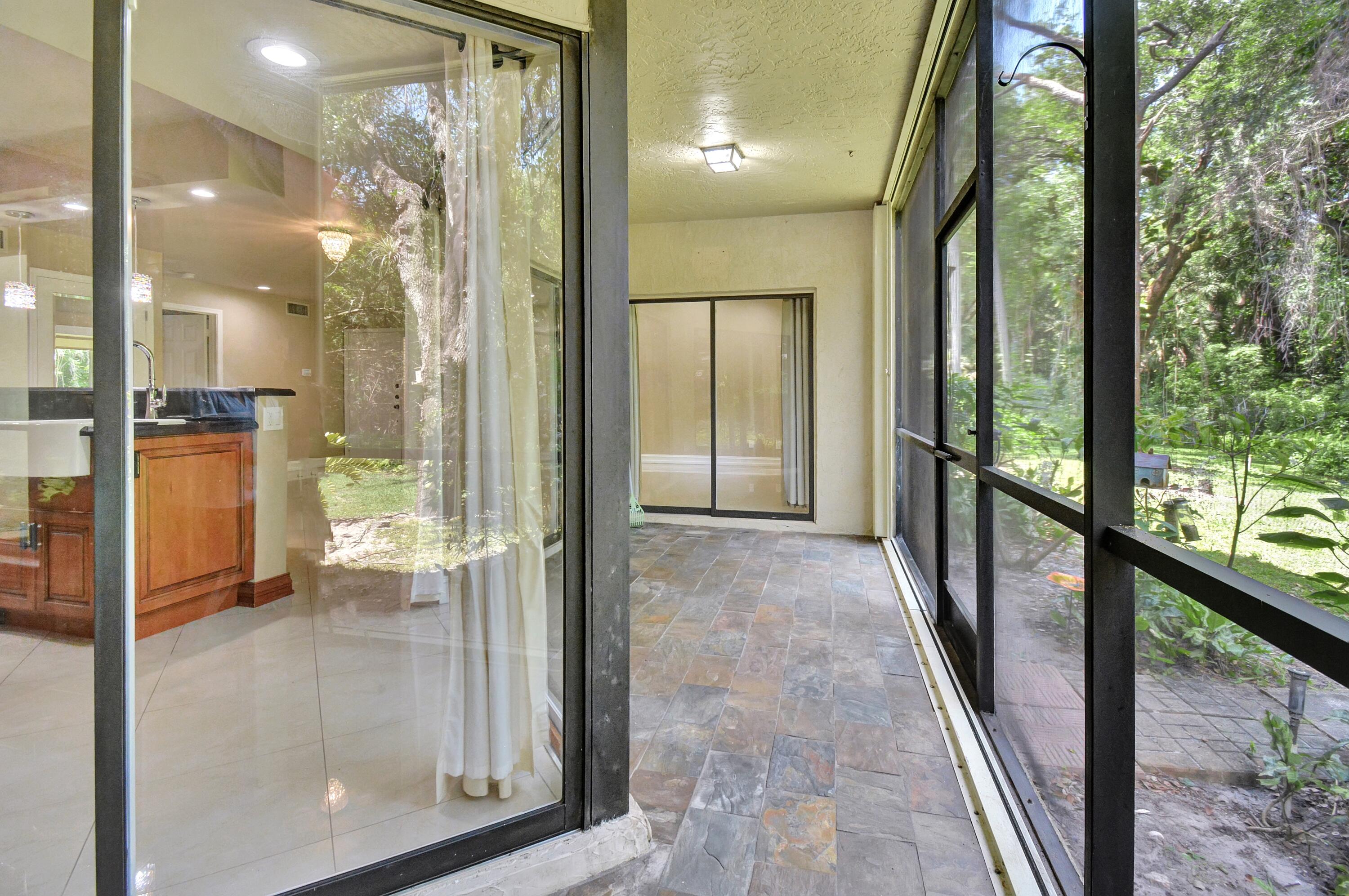 5590 Coach House Circle, Unit A Boca Raton, FL 33486 - Photo 19 of 33 a view of a glass door and the living room