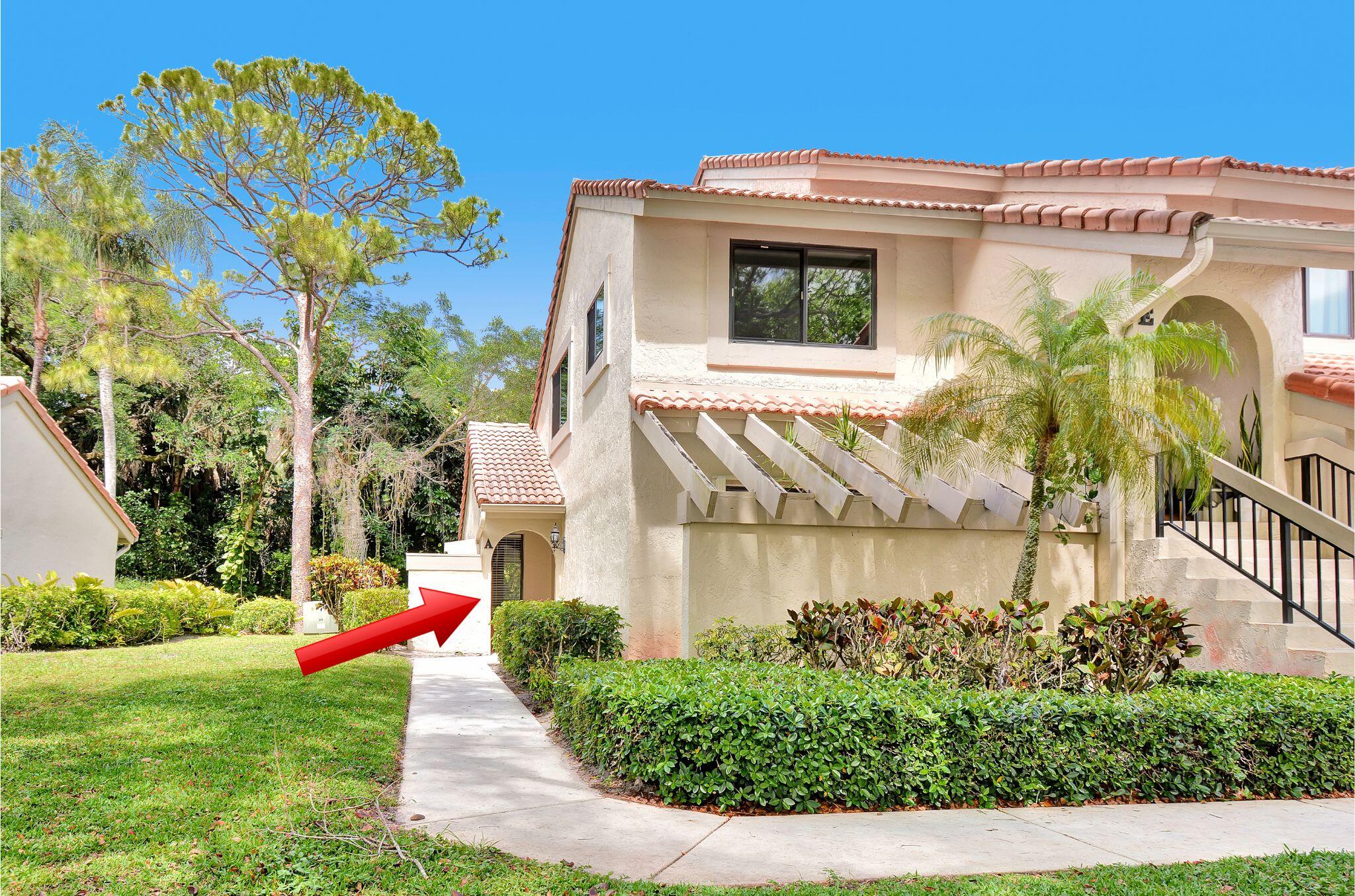 5590 Coach House Circle, Unit A Boca Raton, FL 33486 - Photo 2 of 33 a front view of a house with a yard and outdoor seating