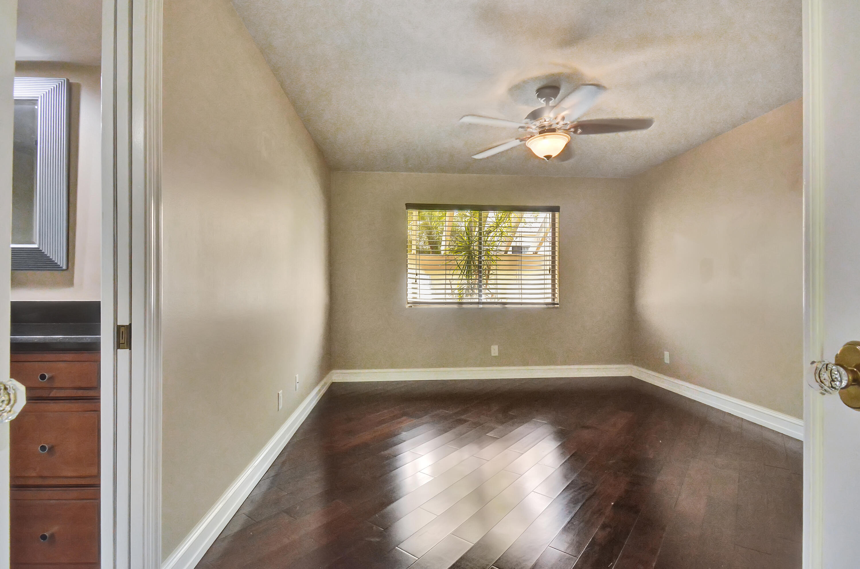 5590 Coach House Circle, Unit A Boca Raton, FL 33486 - Photo 21 of 33 a view of an empty room with wooden floor and a window