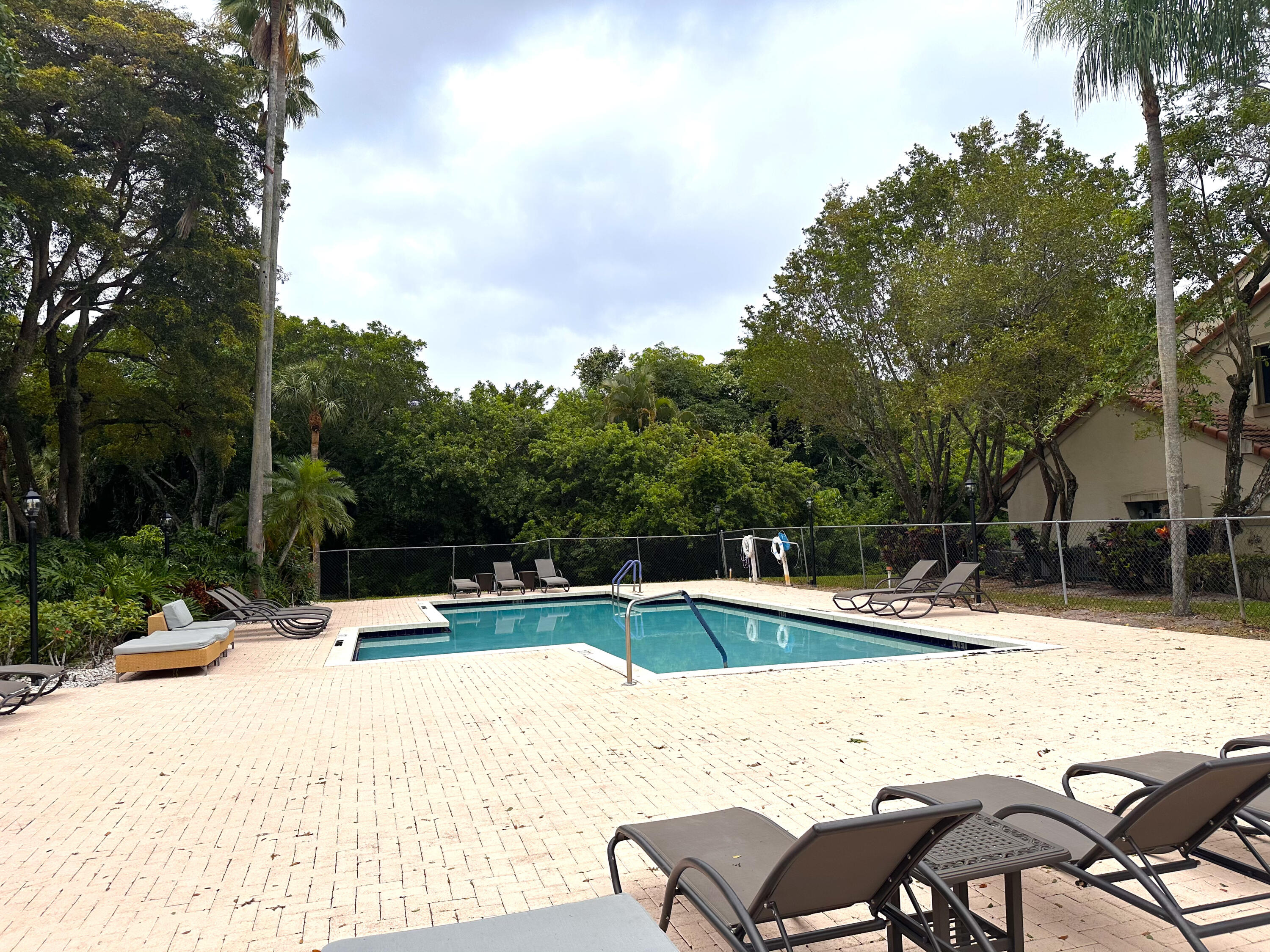 5590 Coach House Circle, Unit A Boca Raton, FL 33486 - Photo 31 of 33 a view of a swimming pool with a lounge chair