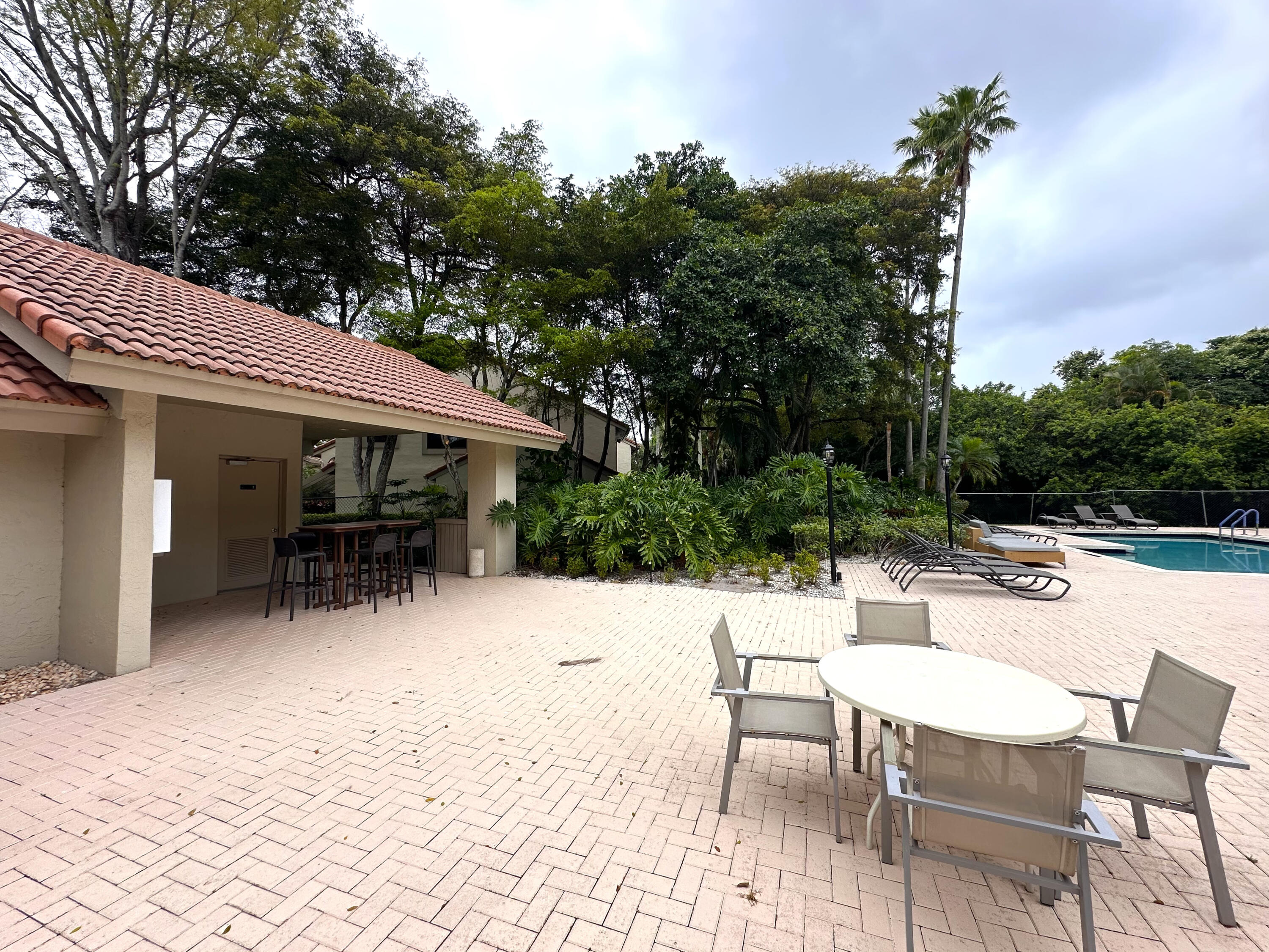 5590 Coach House Circle, Unit A Boca Raton, FL 33486 - Photo 32 of 33 a view of backyard with outdoor seating a patio and plants