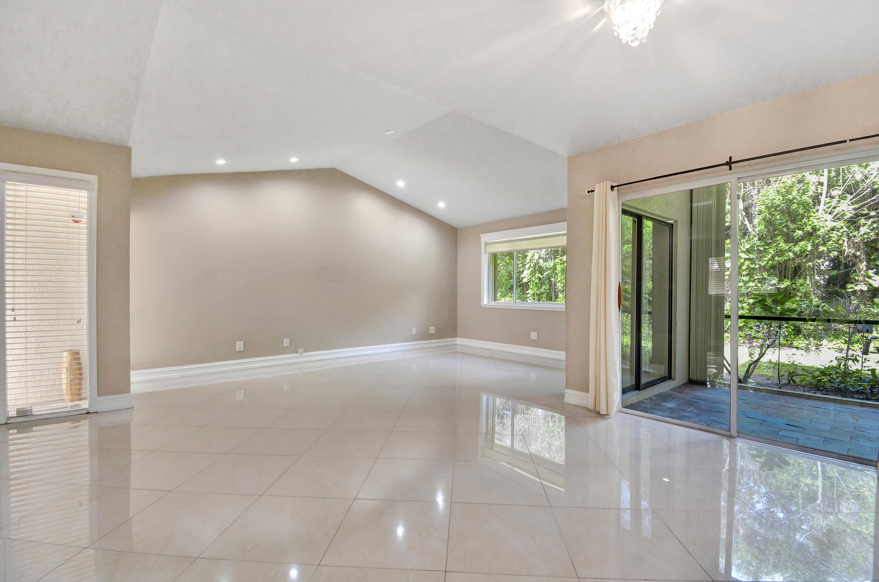 5590 Coach House Circle, Unit A Boca Raton, FL 33486 - Photo 8 of 33 an empty room with floor to ceiling windows and an outdoor view