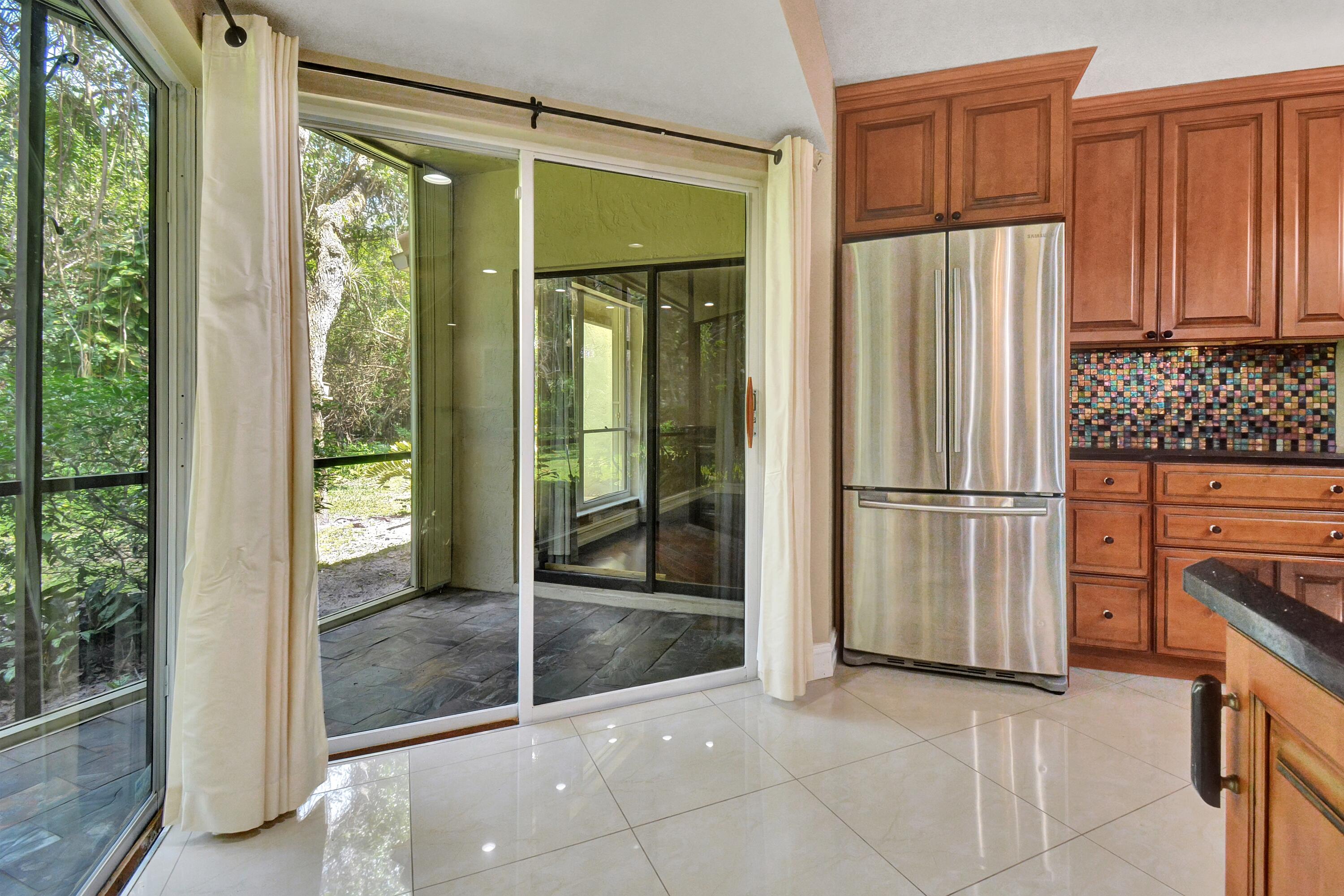 5590 Coach House Circle, Unit A Boca Raton, FL 33486 - Photo 10 of 33 a view of a kitchen with an entryway and wooden floor