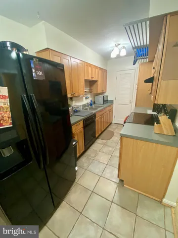 a kitchen with stainless steel appliances granite countertop a sink and a refrigerator