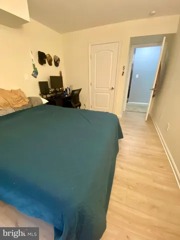 a bed sitting in a bedroom next to a window with wooden floor