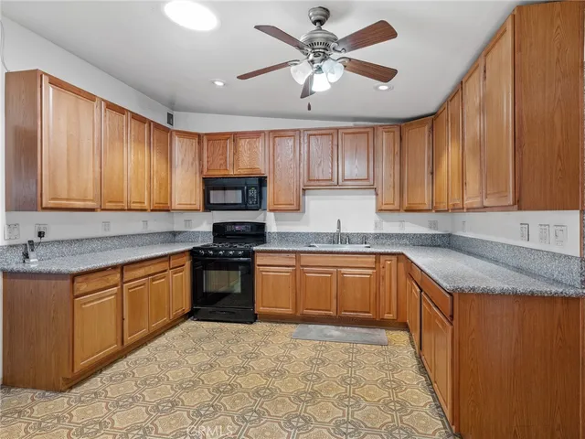 a view of open kitchen with granite countertop a refrigerator and a sink