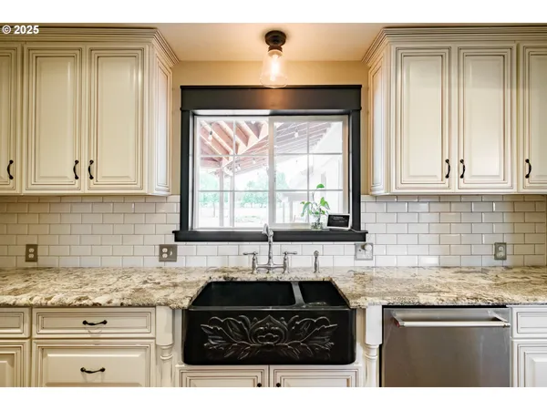 a kitchen with granite countertop a sink stove and cabinets