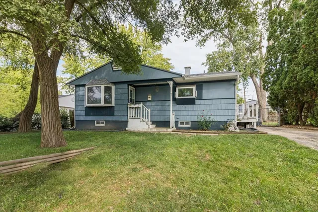 a view of a house with a yard and large tree
