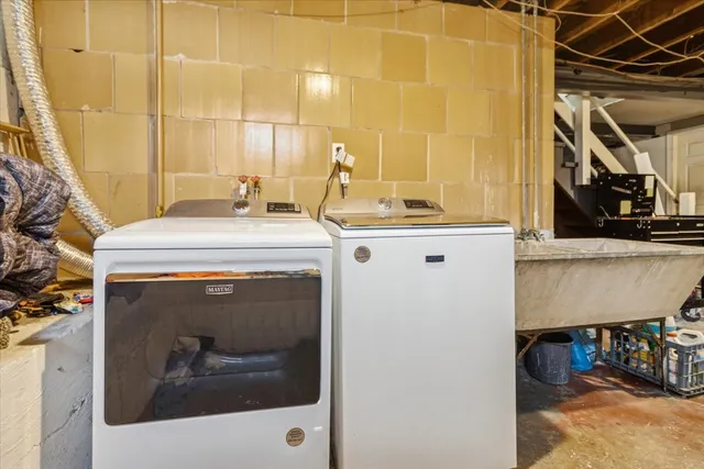 a utility room with a sink and a mirror