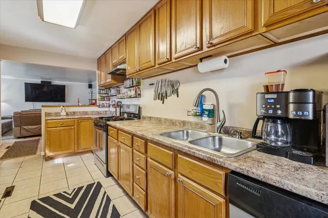a kitchen with stainless steel appliances granite countertop a sink a stove and cabinets