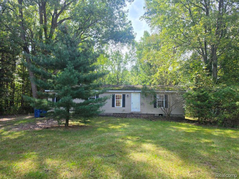 3897 Swaffer Road Millington, MI 48746 - Photo 15 of 16 Light-colored siding exterior, dark shutters, covered entry, front lawn, mature trees