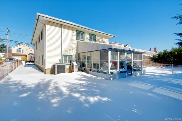 a view of a house with wooden deck and furniture