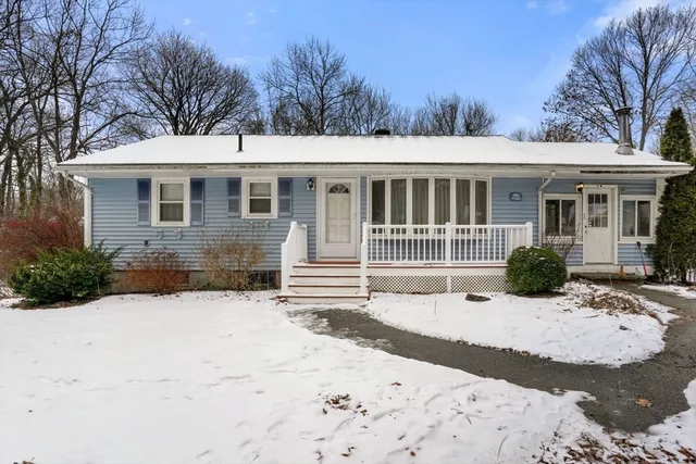a front view of a house with a yard covered in snow